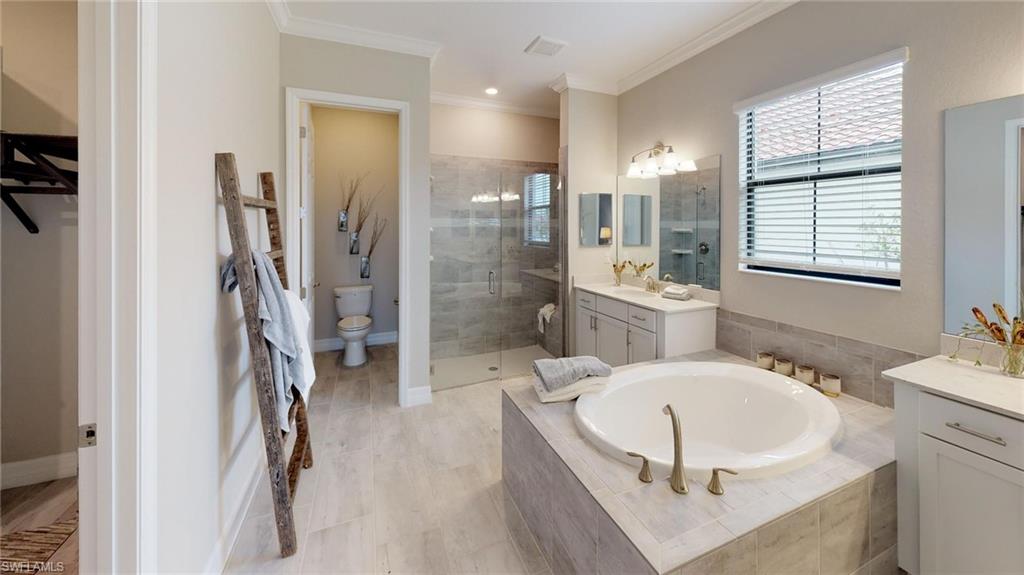 20259 Kingmont Drive Estero, FL 33928 - Photo 11 of 14 a bathroom with a tub sink a mirror and a shower