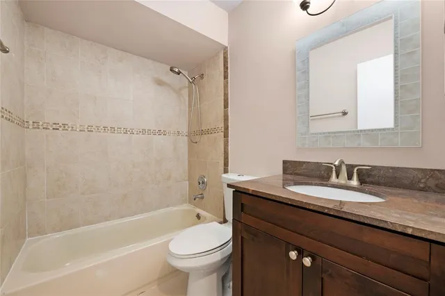 a bathroom with a granite countertop sink toilet mirror and shower