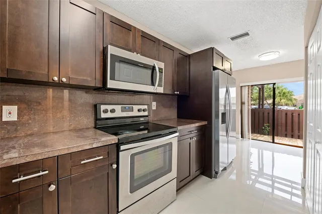 a kitchen with stainless steel appliances granite countertop a stove a microwave and a sink