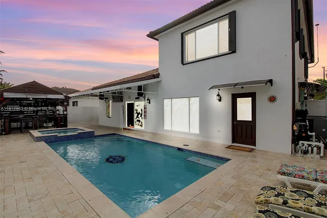 a view of a house with backyard and sitting area
