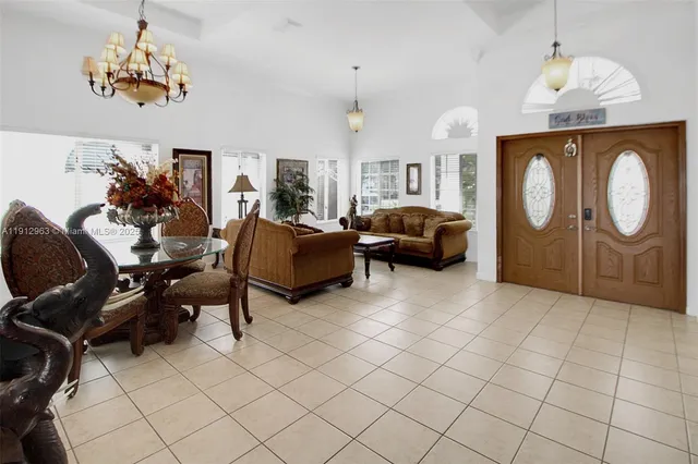 a living room with furniture a chandelier and a mirror