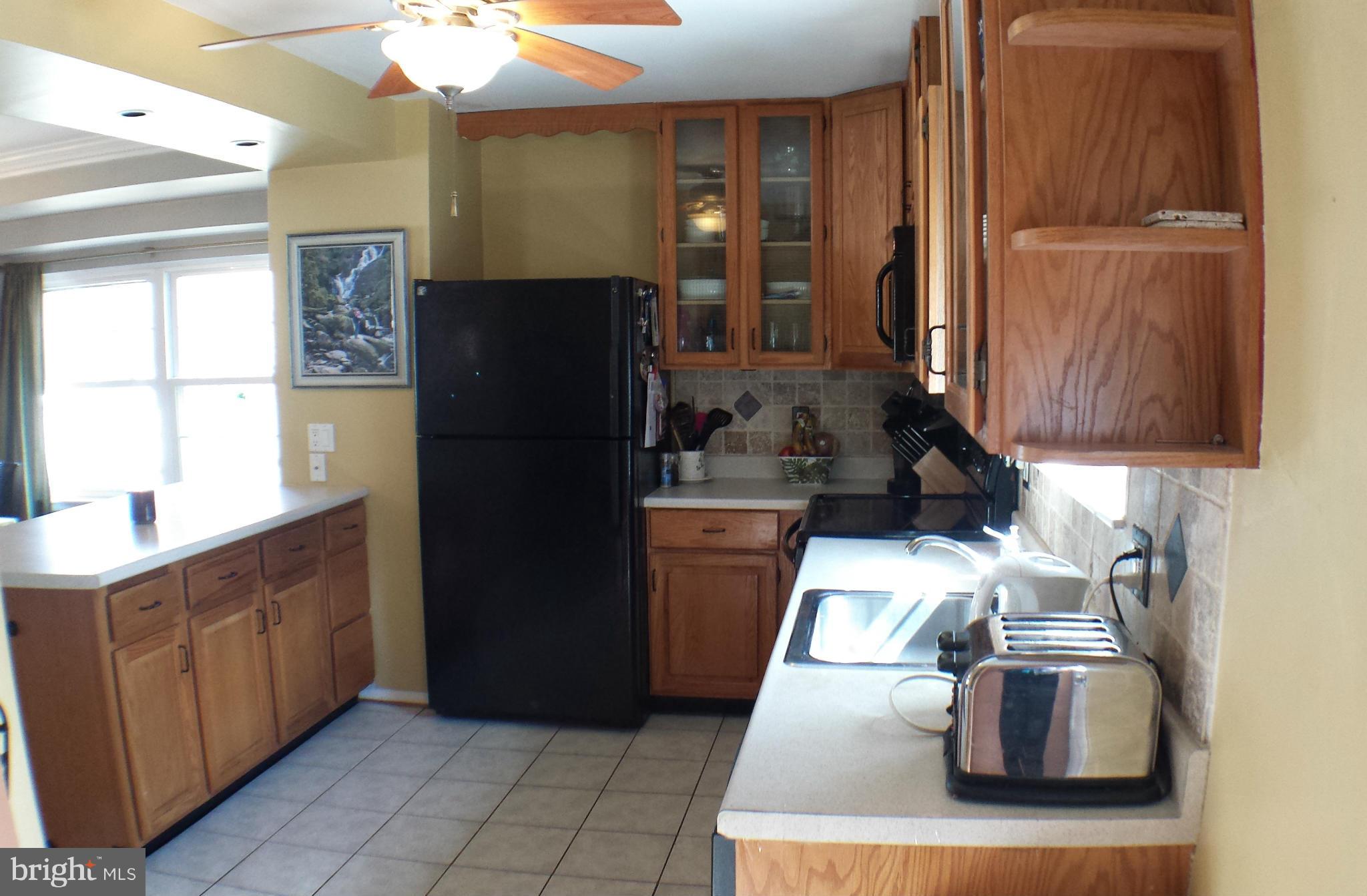 913 Elm Road Baltimore, MD 21227 - Photo 11 of 28 a kitchen with a refrigerator and a sink