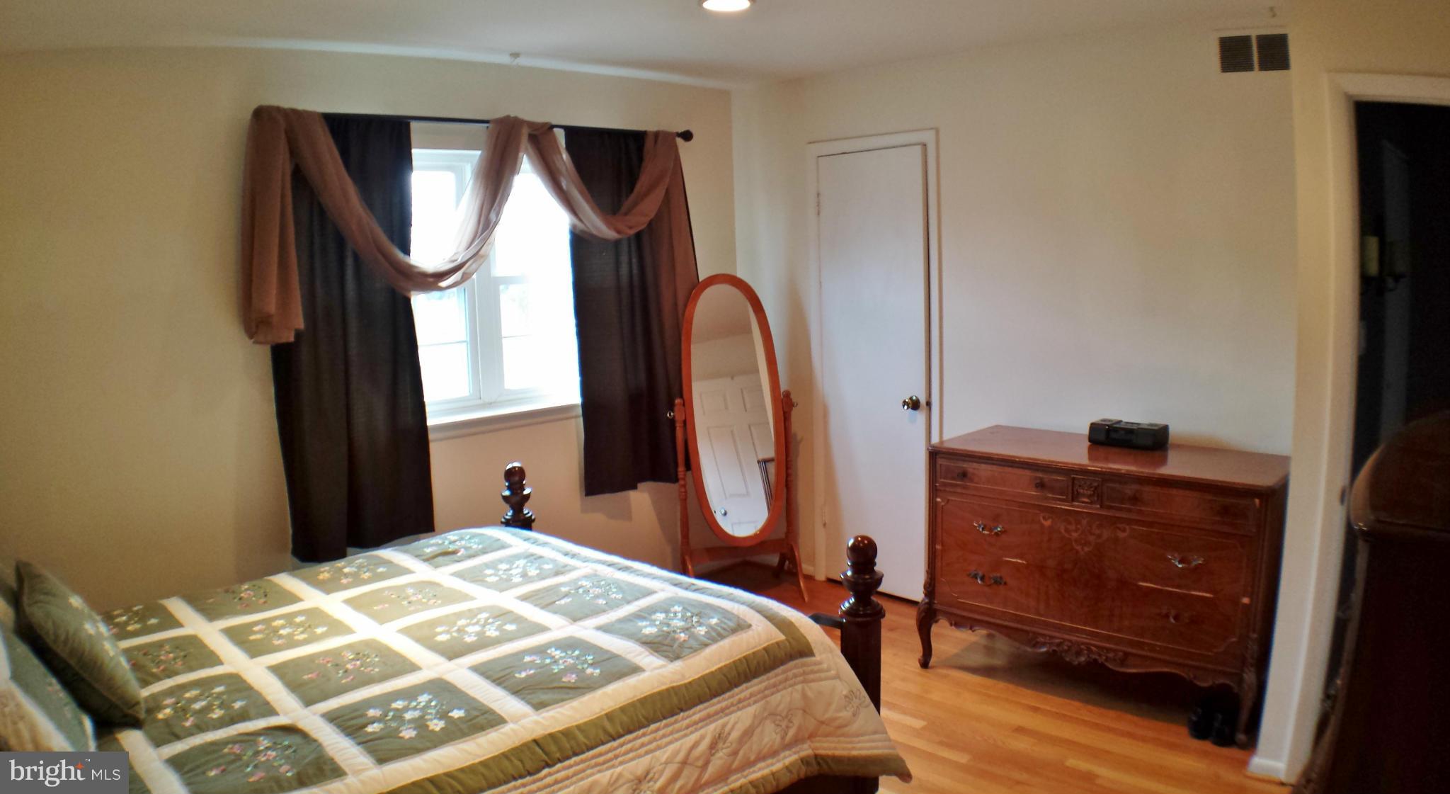 913 Elm Road Baltimore, MD 21227 - Photo 14 of 28 a bedroom with a bed a dresser and mirror