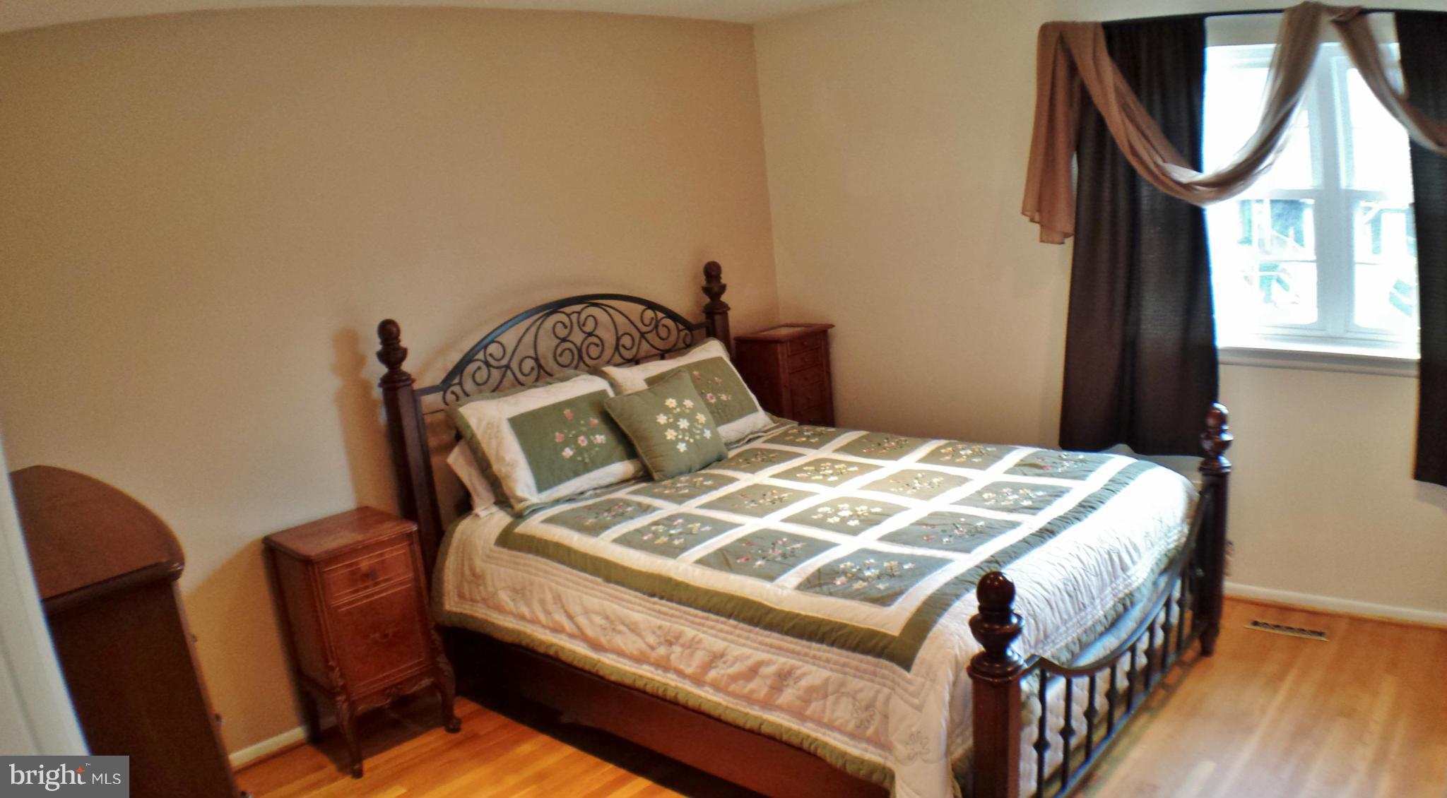 913 Elm Road Baltimore, MD 21227 - Photo 15 of 28 a bed sitting in a bedroom next to a window
