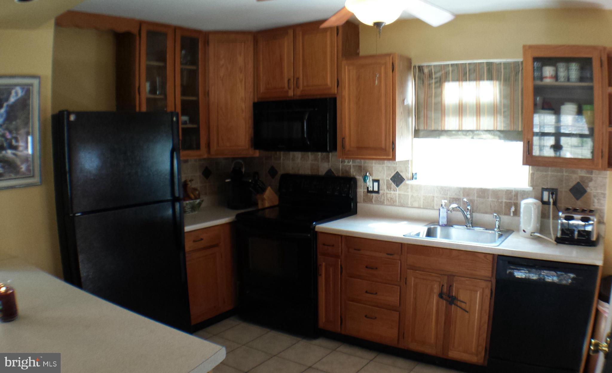 913 Elm Road Baltimore, MD 21227 - Photo 10 of 28 a kitchen with a refrigerator and a sink