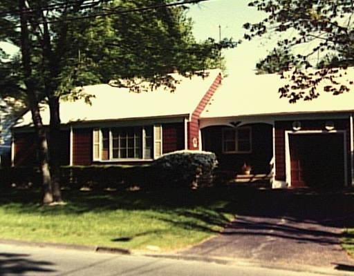 a front view of a house with a yard tree and outdoor seating
