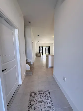 a view of a hallway with furniture and floor to ceiling window