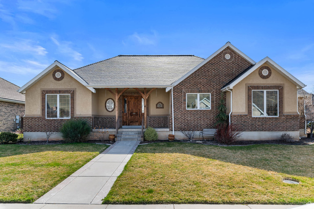 1618 East 970 South Springville, UT 84663 - Photo 1 of 1 View of front of property with a porch, brick siding, a front yard, stucco siding, and a shingled roof