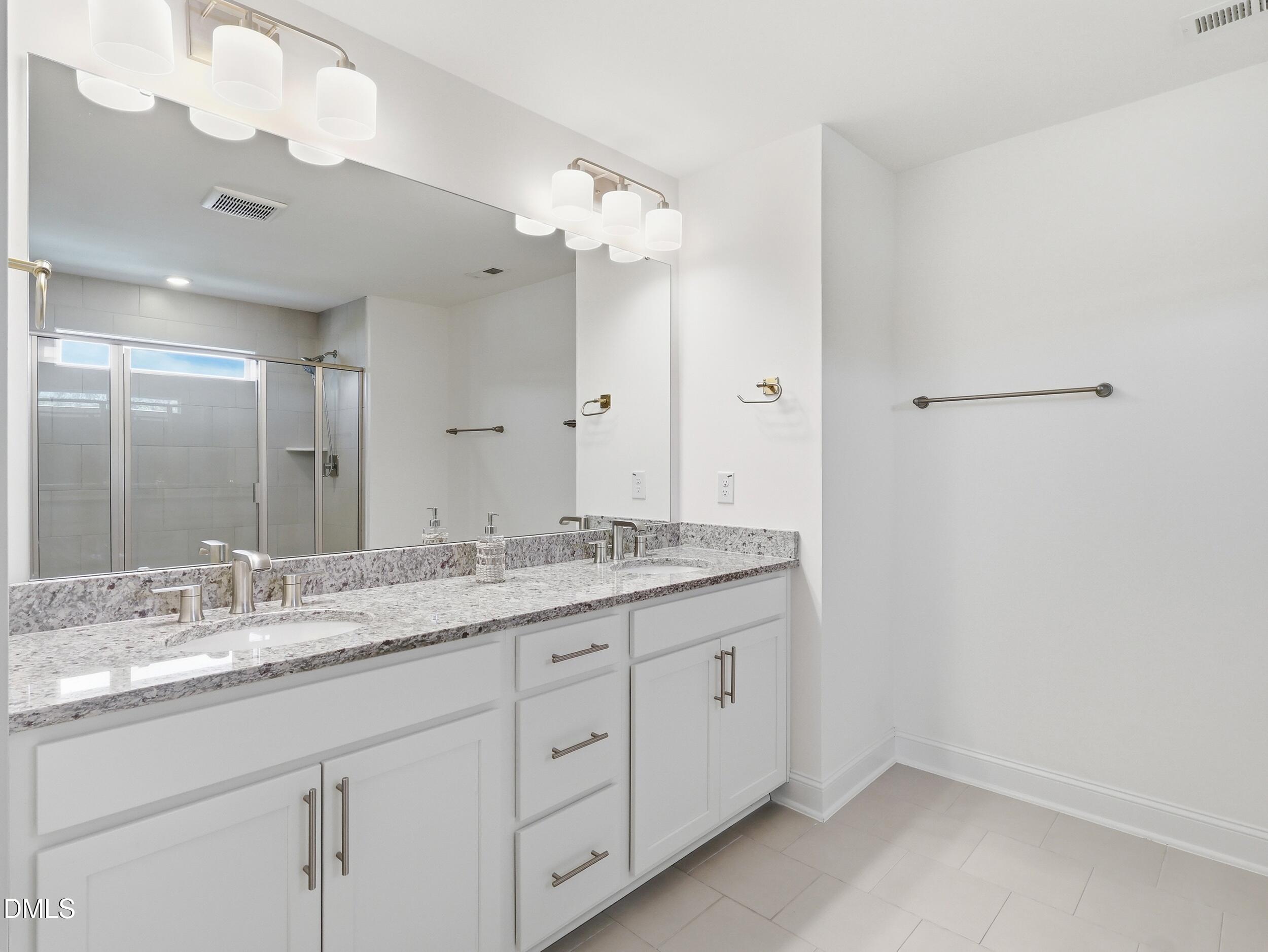 2709 Womble Ridge Drive New Hill, NC 27562 - Photo 35 of 60 a bathroom with a granite countertop sink and a mirror