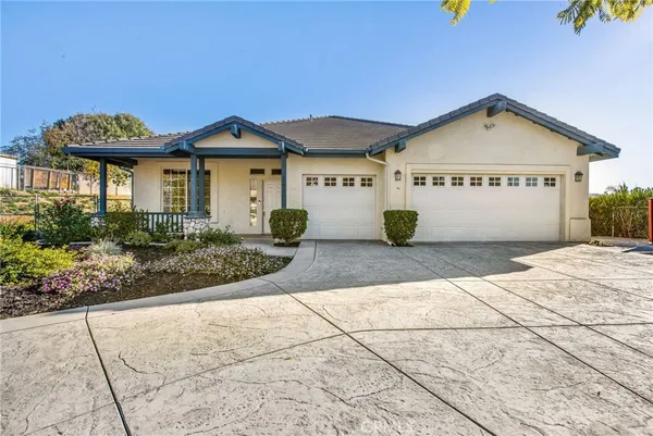 a view of a white house with large windows and a small yard