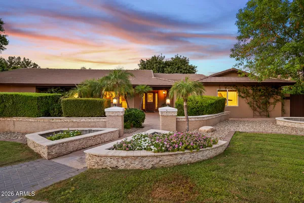 a front view of a house with a yard and lake view
