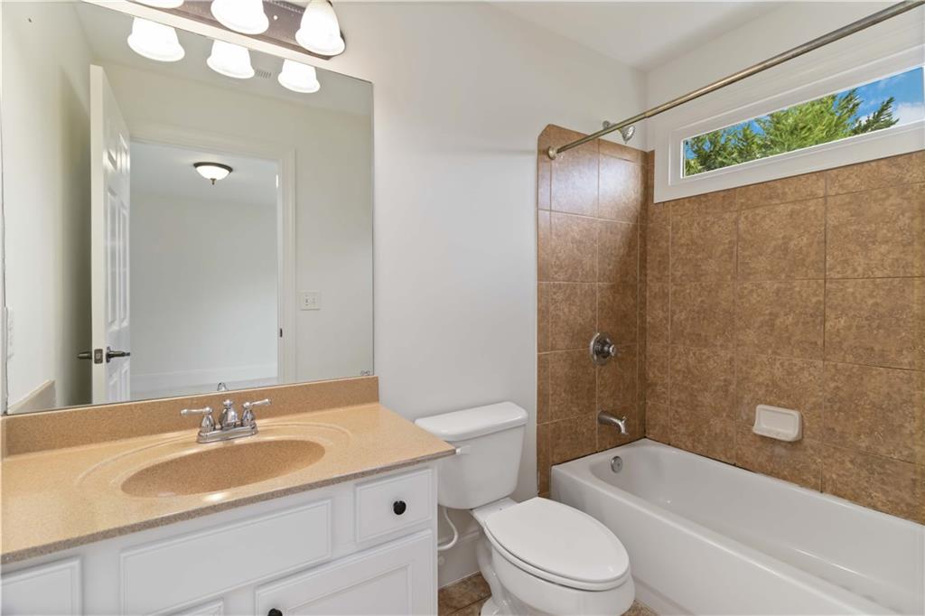 3320 Spencer Street Cumming, GA 30041 - Photo 24 of 90 a bathroom with a granite countertop sink toilet mirror and bathtub