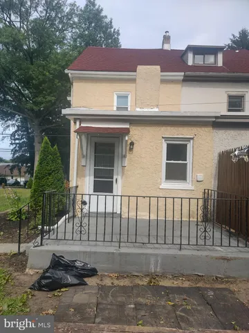 a view of a white house with large windows and a small yard