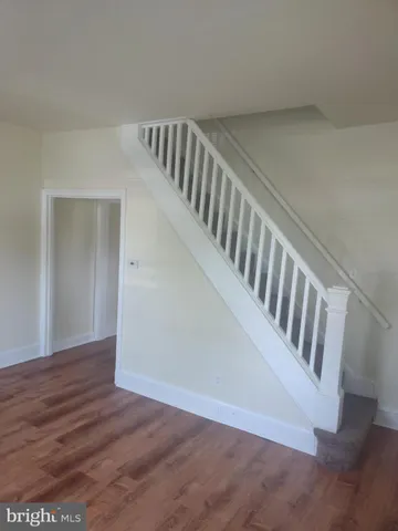 a view of staircase with white walls and wooden floor