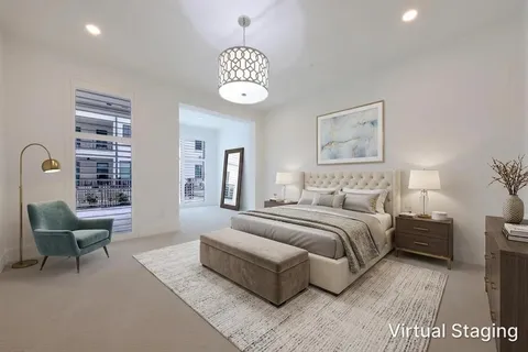 a spacious bedroom with a bed a couch and a potted plant on the dresser