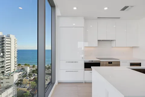 a view of a kitchen with kitchen island a sink a stove and a refrigerator