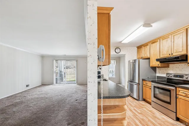 a kitchen with stainless steel appliances granite countertop a refrigerator a stove and a sink with cabinets