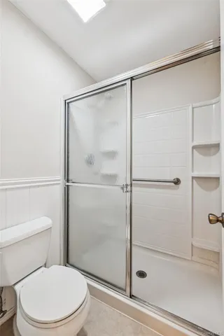 a white toilet sitting next to a shower