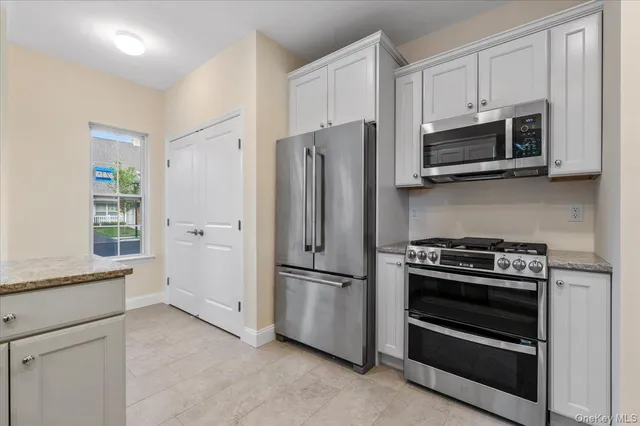 a kitchen with stainless steel appliances white cabinets and a stove top oven