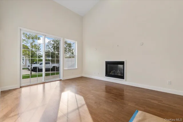 a view of a big room with wooden floor and windows