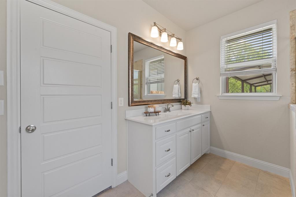 1001 Resolute Road Millsap, TX 76066 - Photo 19 of 40 a bathroom with a sink a vanity and a mirror