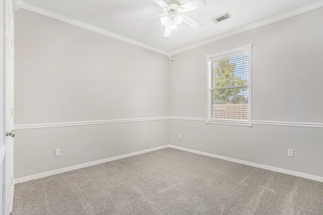 an empty room with a window and a fan
