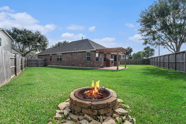 a view of a house with a backyard and a patio