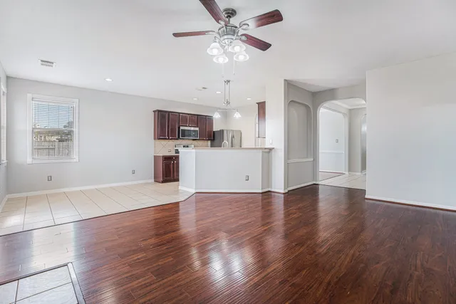 a view of a kitchen with a kitchen island wooden floor and a ceiling fan