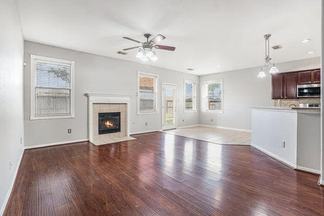 a view of an empty room with window and wooden floor
