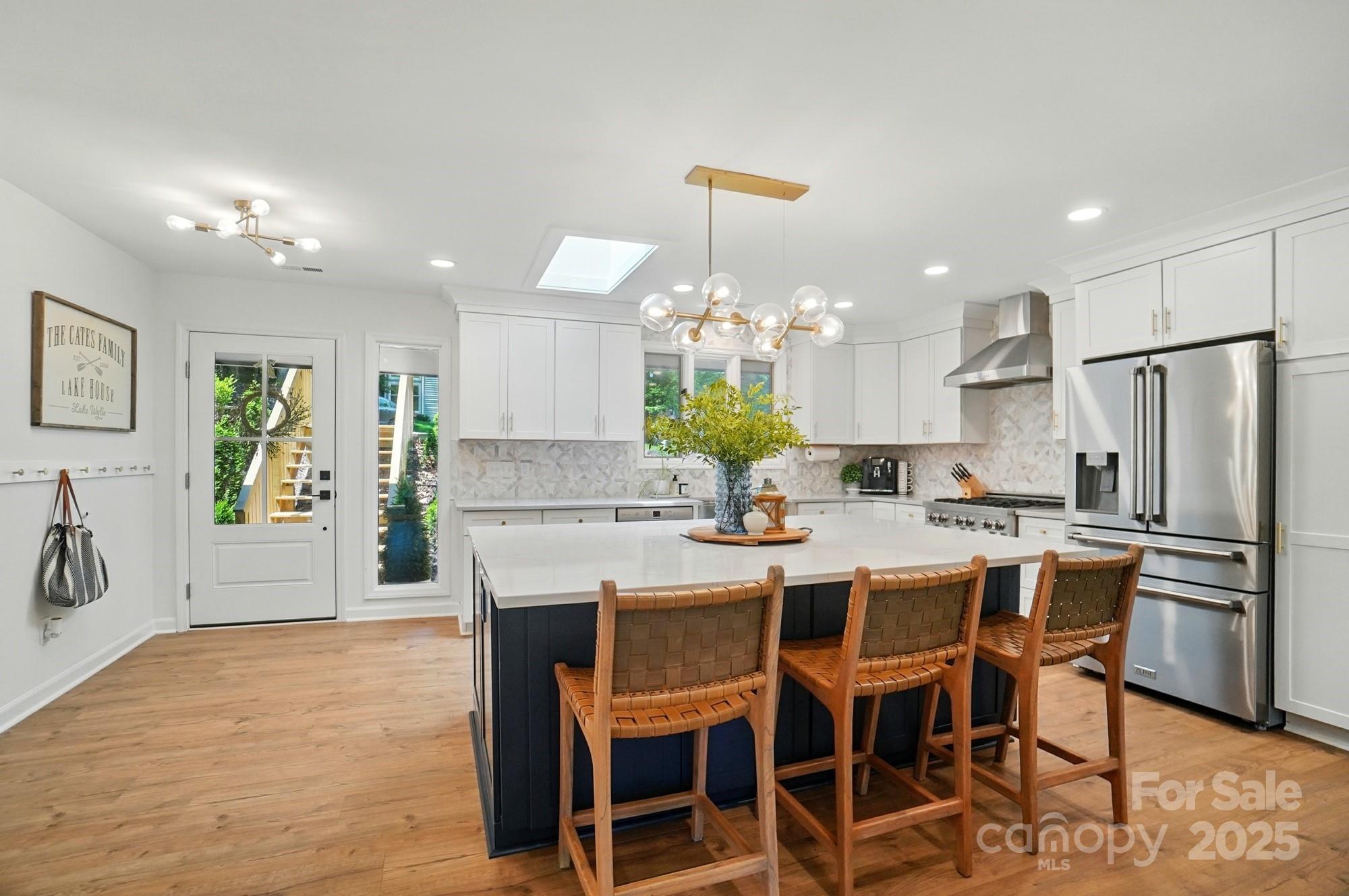 10043 Tepa Place Tega Cay, SC 29708 - Photo 7 of 43 a kitchen with kitchen island a dining table and chairs