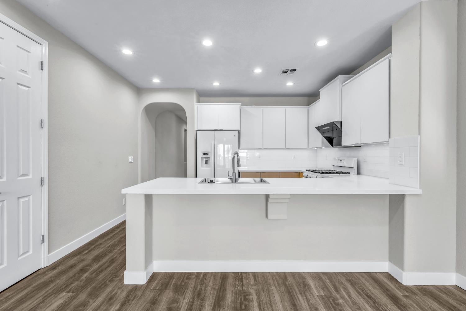 1839 Dawnelle Way Sacramento, CA 95835 - Photo 19 of 56 a large white kitchen with kitchen island a sink appliances and a counter space