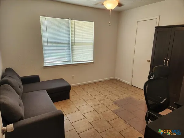 a living room with furniture and a lamp
