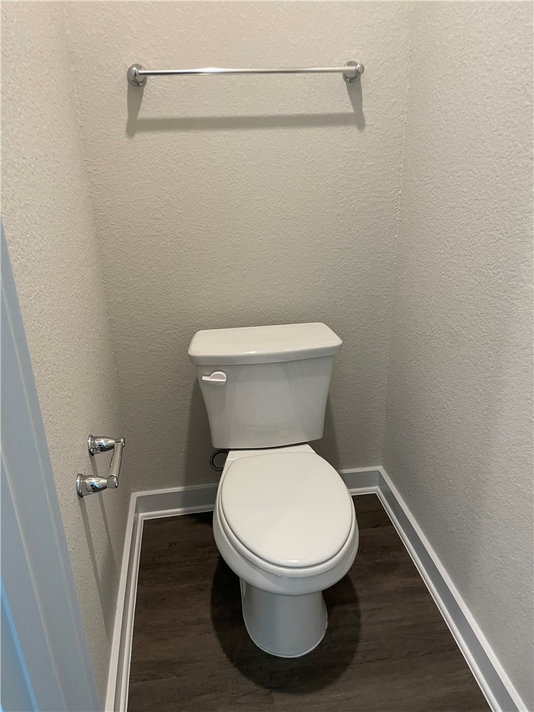 609 Paddock Lane Georgetown, TX 78626 - Photo 13 of 40 Rich wood-look flooring sets a modern foundation for this private powder room alcove.