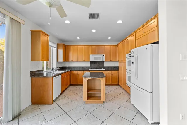a kitchen with stainless steel appliances granite countertop a refrigerator and a stove