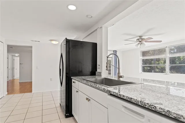 a kitchen with granite countertop a refrigerator and a sink