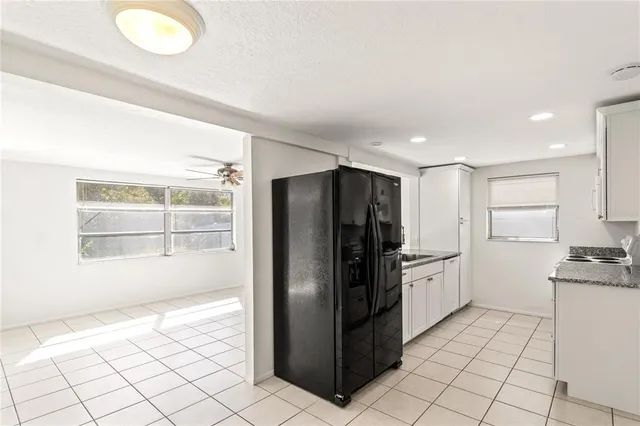 a kitchen with stainless steel appliances kitchen island granite countertop a refrigerator and a sink