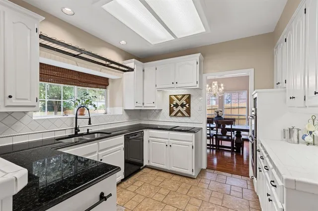 a kitchen with granite countertop a stove and a sink