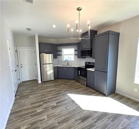a kitchen with stainless steel appliances kitchen island granite countertop a refrigerator and a sink