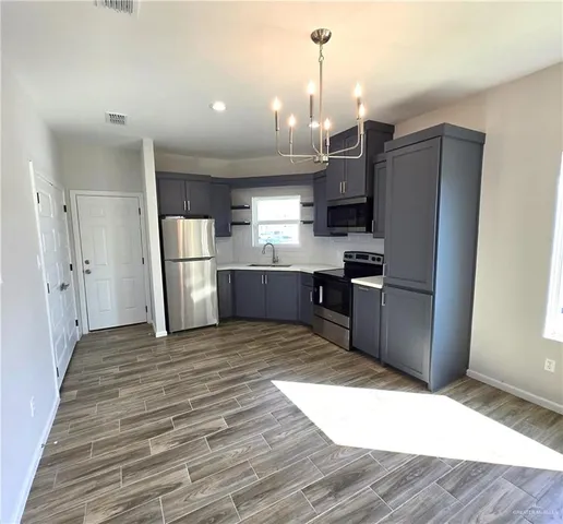 a kitchen with stainless steel appliances kitchen island granite countertop a refrigerator and a sink