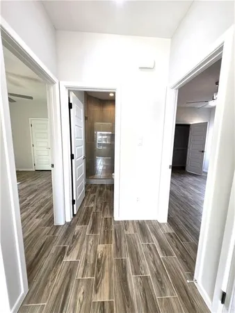 a view of a hallway with wooden floor and staircase