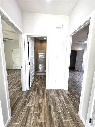 a view of a hallway with wooden floor and staircase
