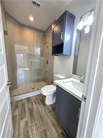 a bathroom with a sink a toilet and shower