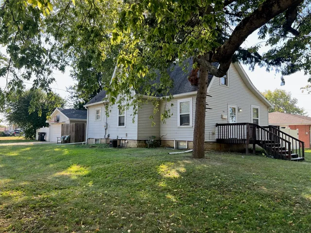 a view of a yard in front of a house with large trees