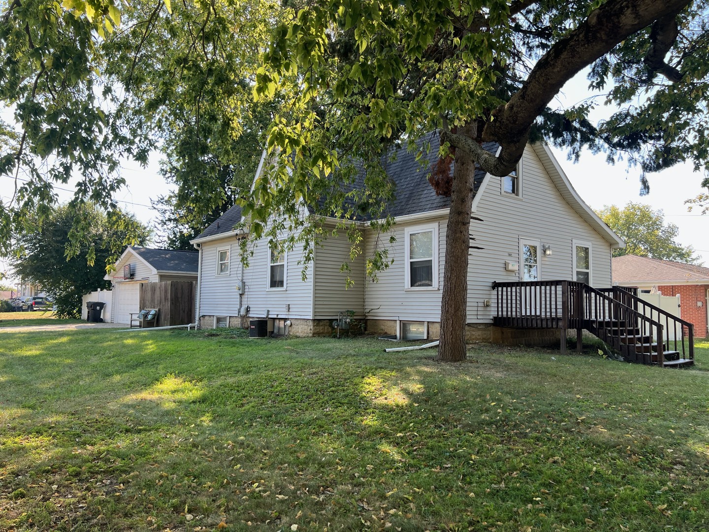 a view of a yard in front of a house with large trees