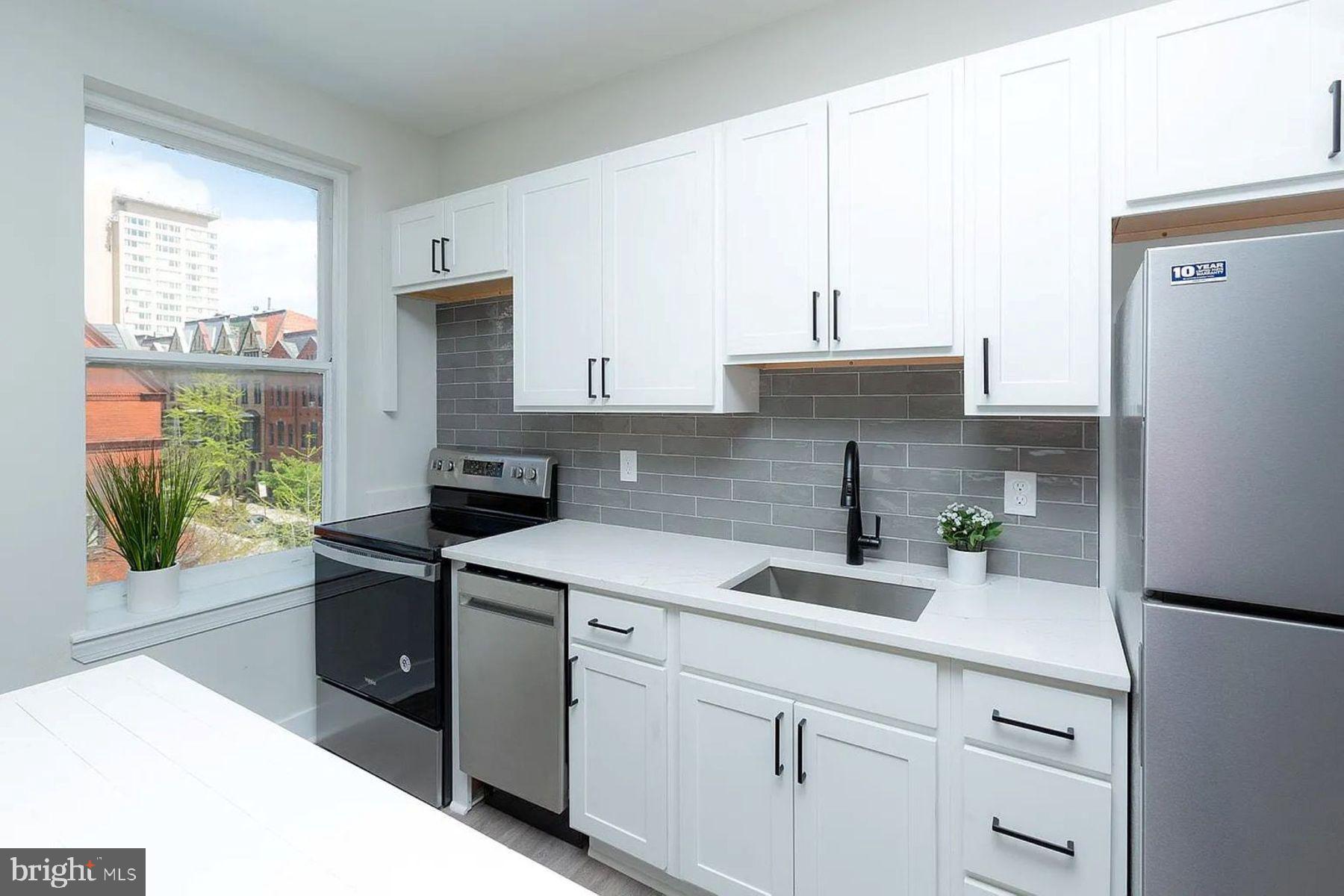 1122 North Calvert Street, Unit 1 Baltimore, MD 21202 - Photo 2 of 8 a kitchen with a sink cabinets and window