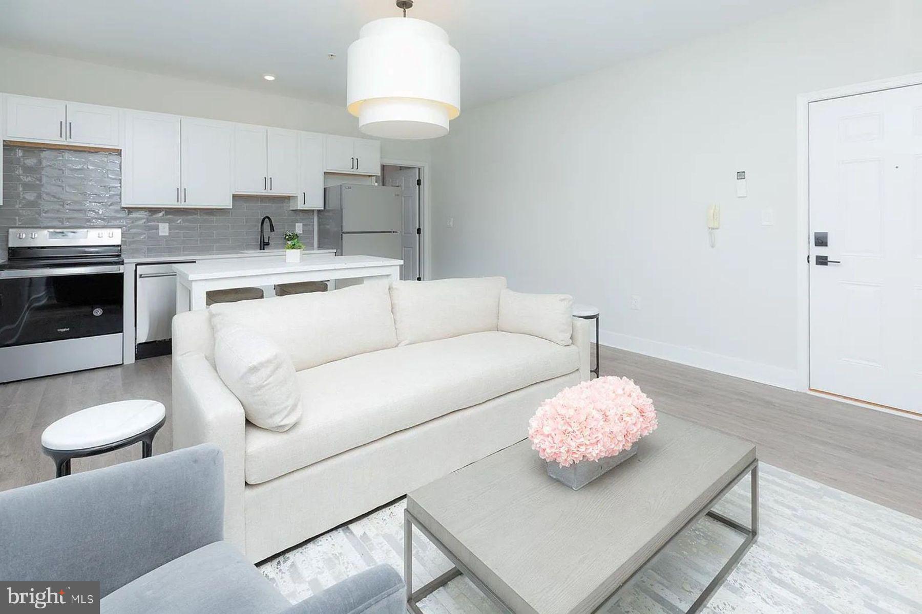 1122 North Calvert Street, Unit 1 Baltimore, MD 21202 - Photo 3 of 8 a living room with furniture and a table