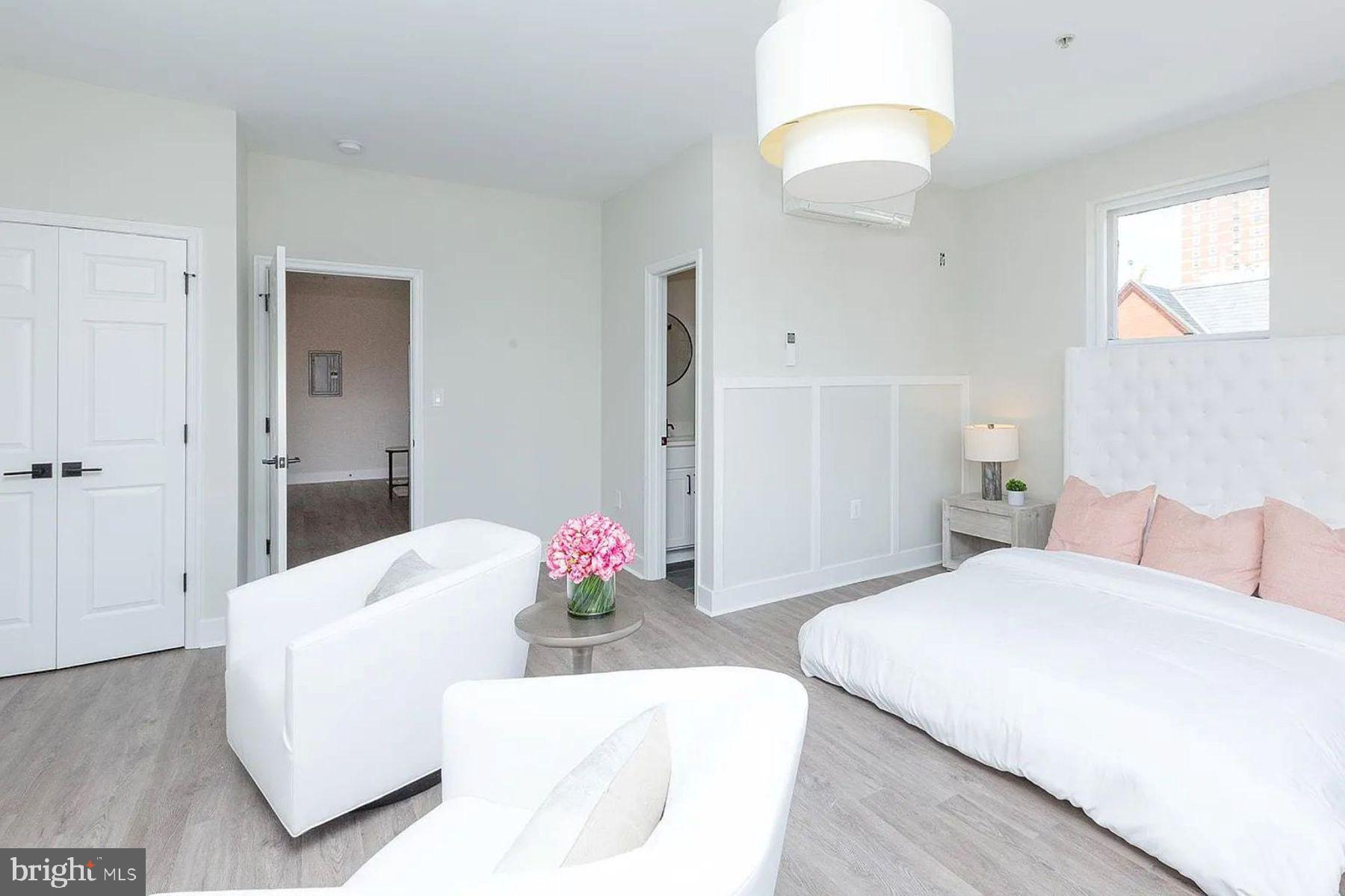 1122 North Calvert Street, Unit 1 Baltimore, MD 21202 - Photo 7 of 8 a bedroom with a bed and a chandelier