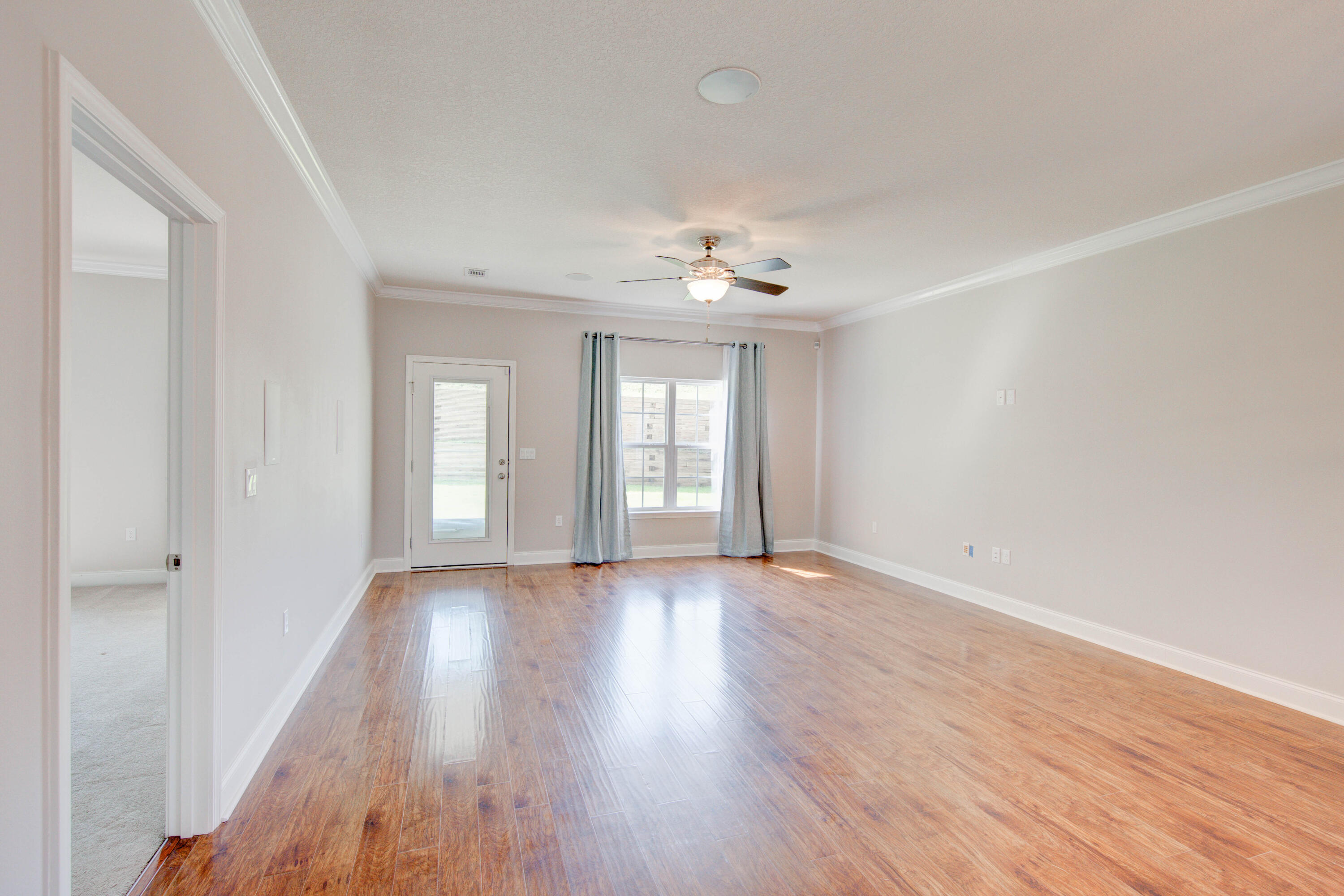 4557 Hermosa Road Crestview, FL 32539 - Photo 11 of 29 a view of an empty room with wooden floor and a window