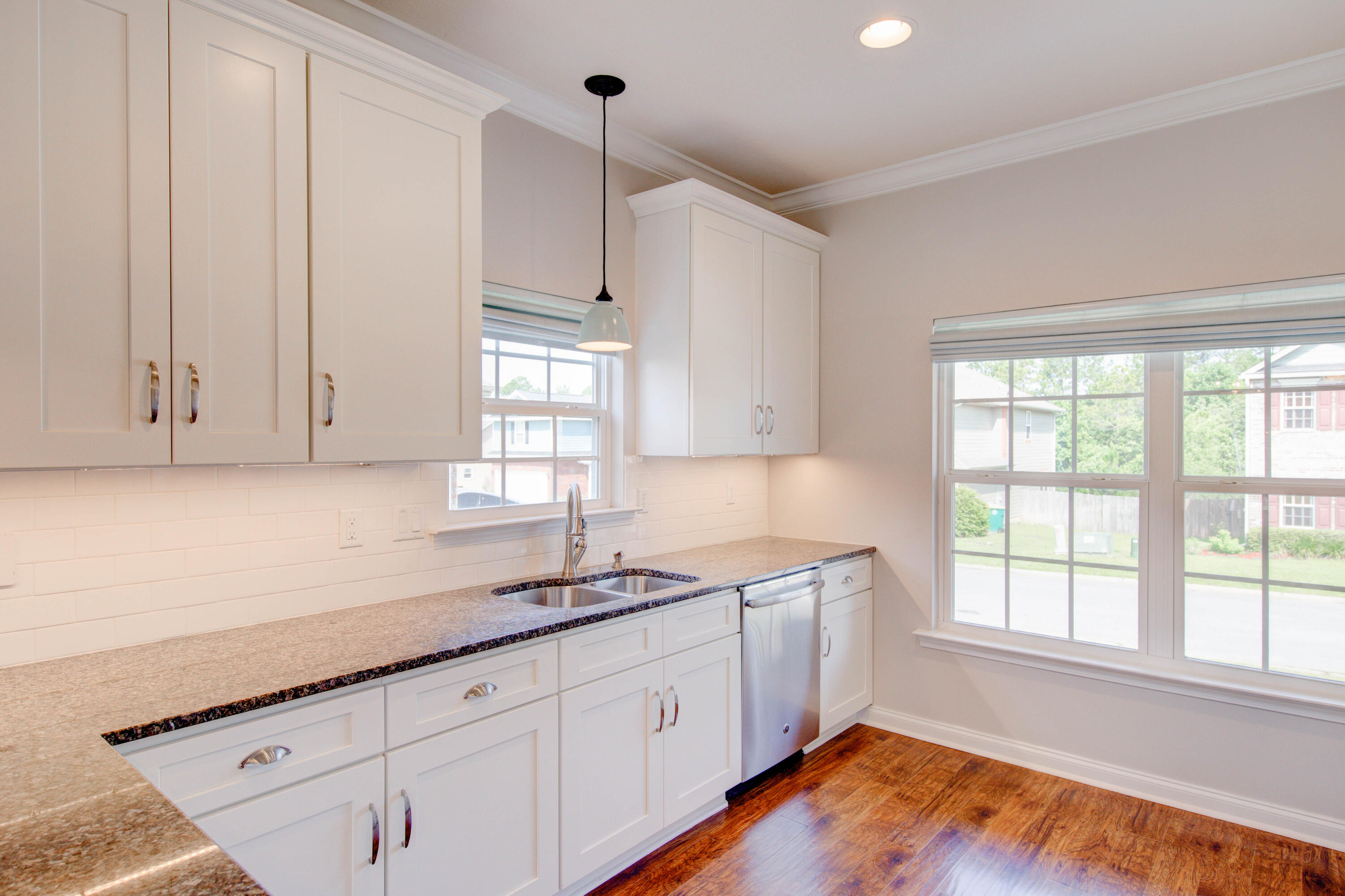4557 Hermosa Road Crestview, FL 32539 - Photo 12 of 29 a kitchen with granite countertop white cabinets and a large window
