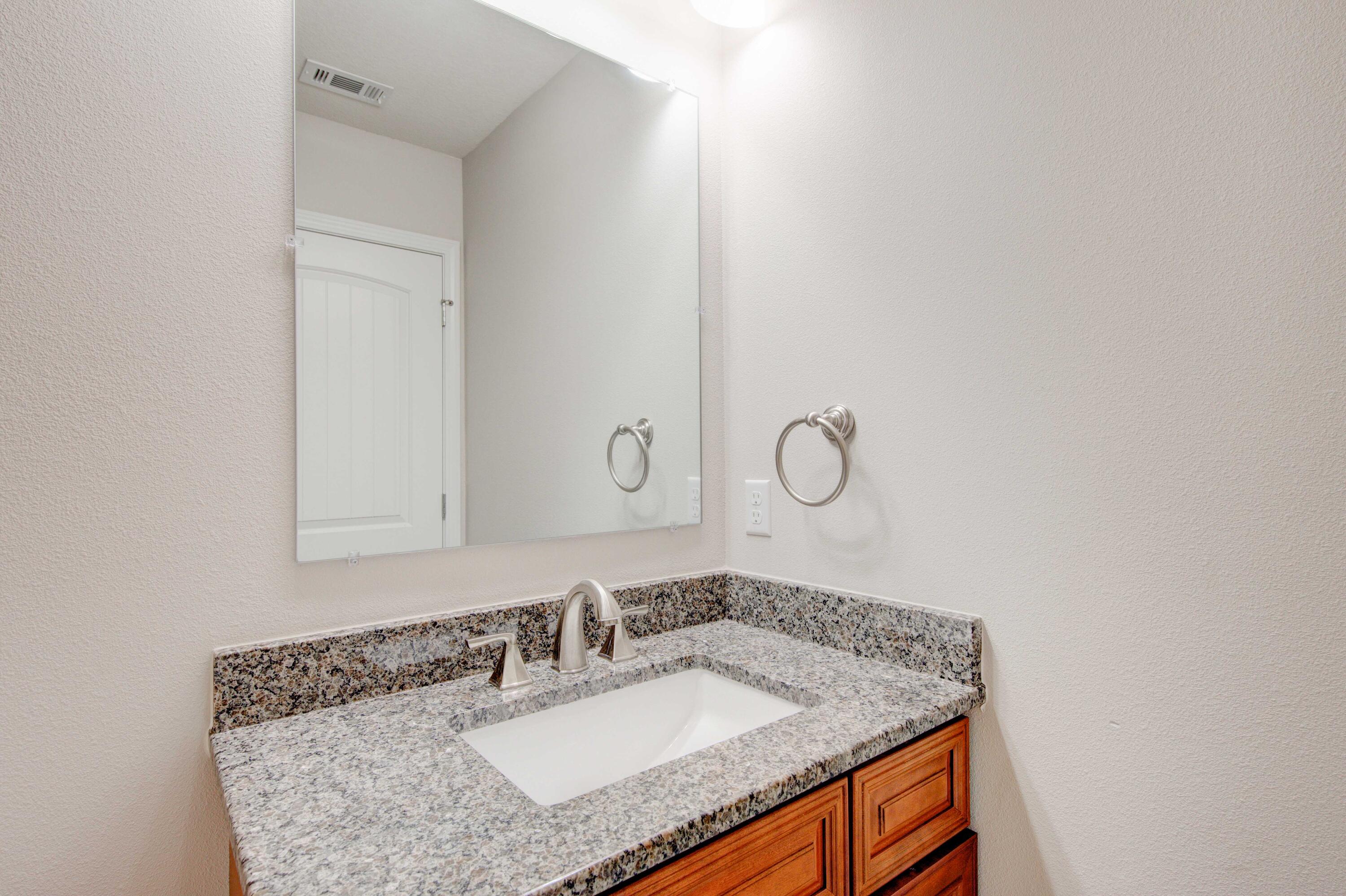 4557 Hermosa Road Crestview, FL 32539 - Photo 22 of 29 a bathroom with a granite countertop sink and a mirror